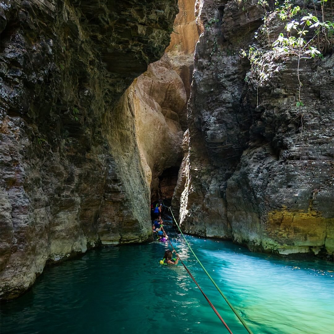 Guests swimming through the canyon to La Leona Waterfall