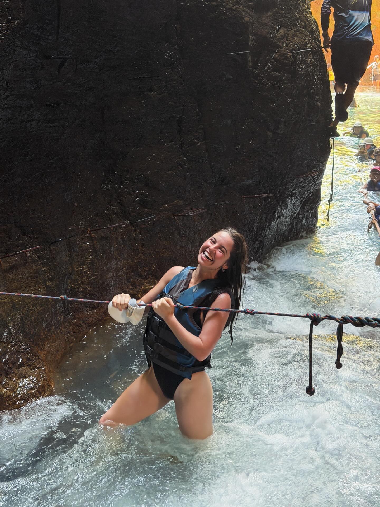 Guest crossing the river on the La Leona Waterfall hike